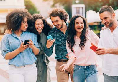 Group of friends texting on the street