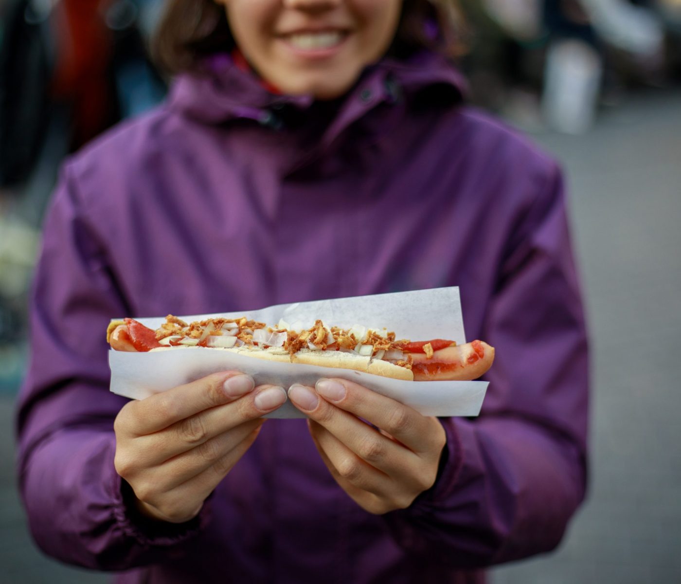 Young Woman eating hot dog in Copenhagen