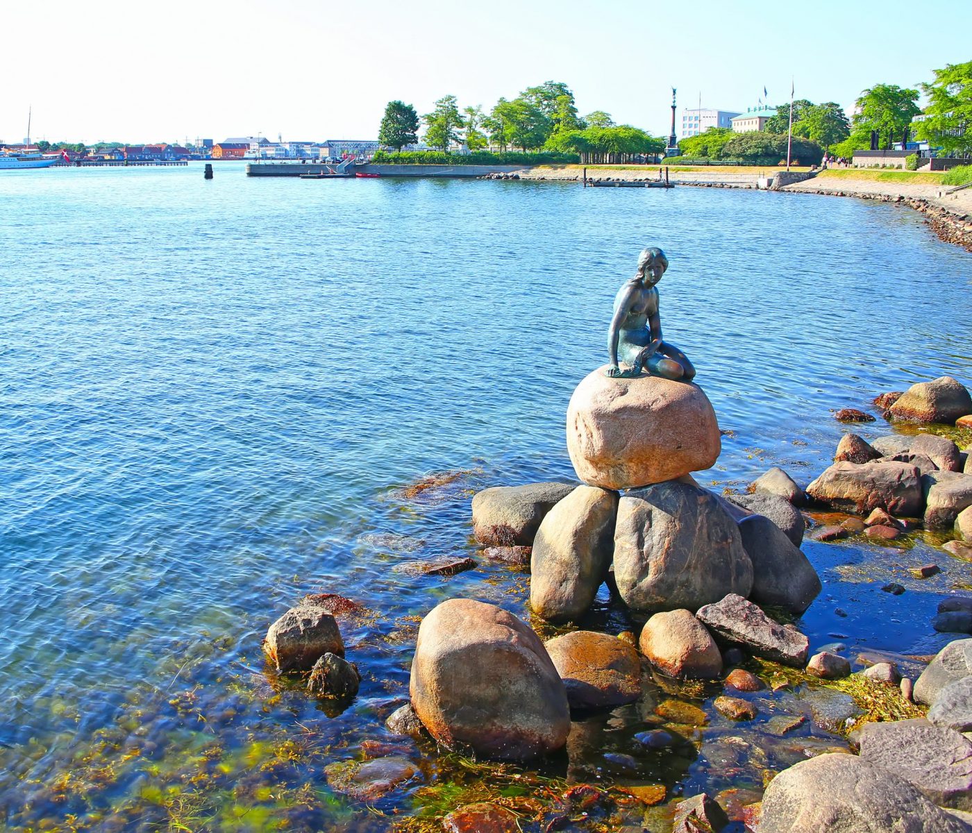 Langelinie promenade with the iconic little mermaid statue & landmark in the foreground and the harbour in the background, Copenhagen, Denmark.